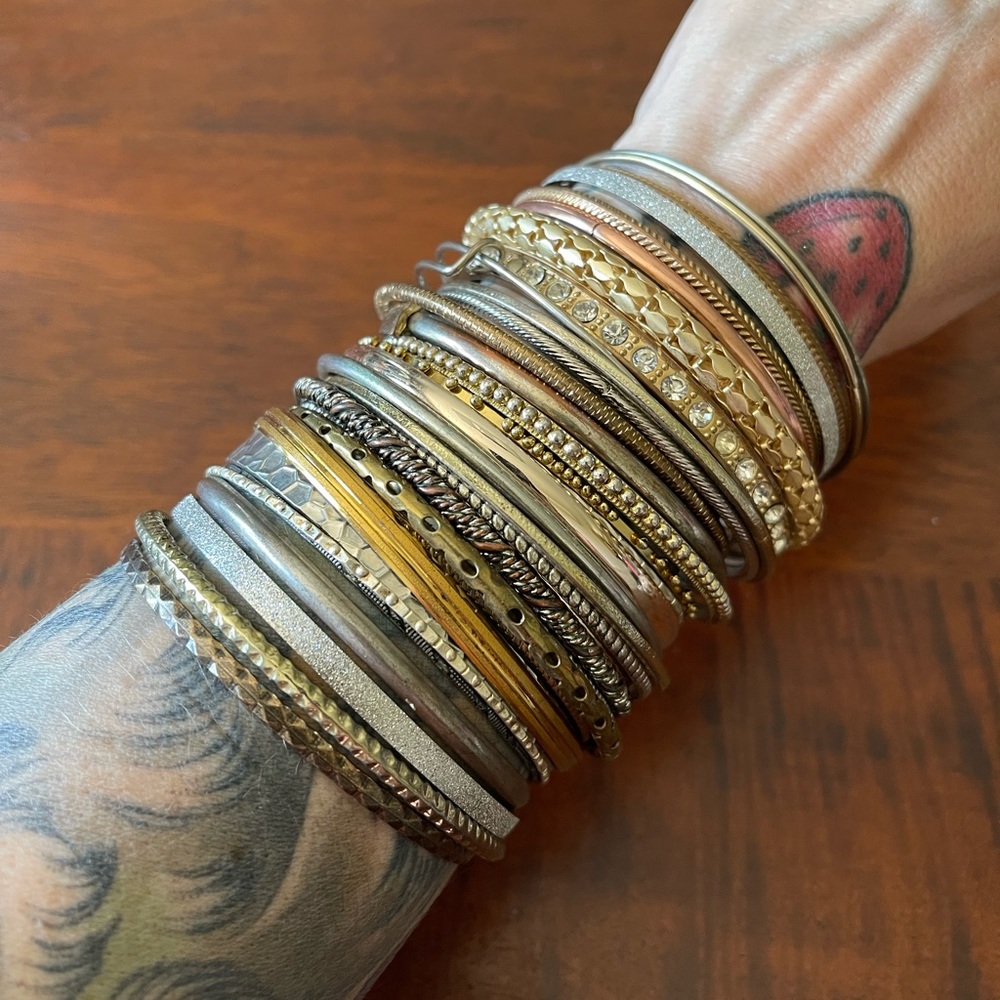 Lot of 34 bangles gold and silver tone some with crystals or charms